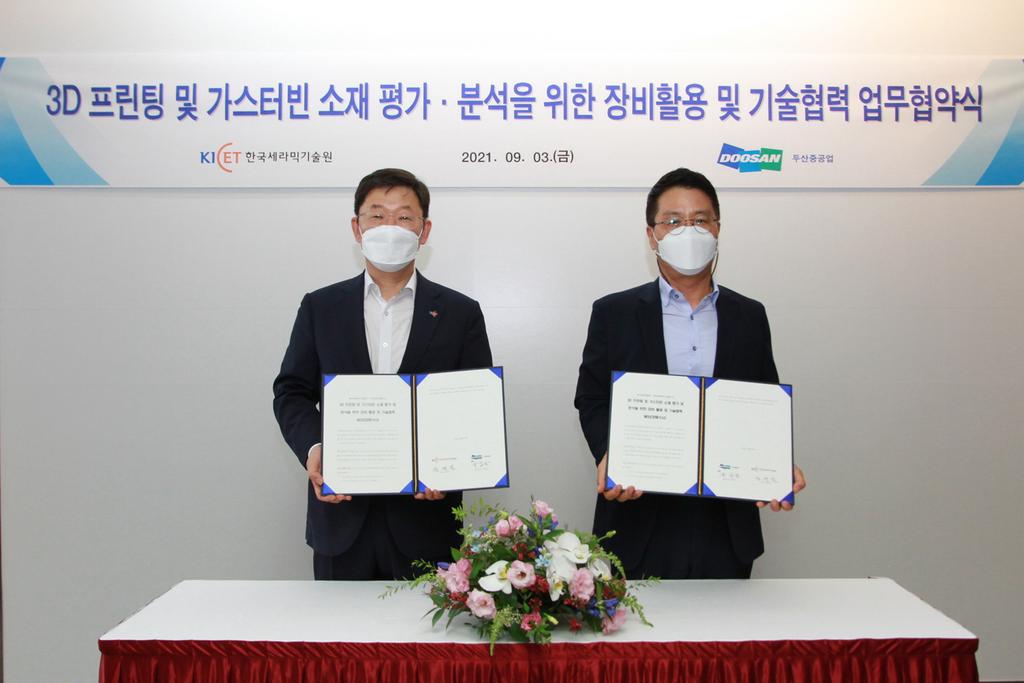 창원 두산중공업 본사에서 한국세라믹기술원 정연길 원장(왼쪽)과 두산중공업 기술혁신연구원 육심균 원장(오른쪽)이 3D 프린팅·가스터빈 소재 기술협력 MOU를 체결 후 기념촬영을 하고 있다.